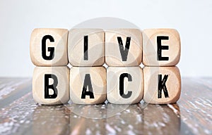 Give Back word written on wood block. Give Back text on table, concept