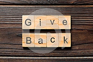 Give back word written on wood block. Give back text on wooden table for your desing, Top view concept