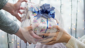 Give gift. Close up hands of couple in love giving a gift box . Happy relationship in outdoor scene. Love and