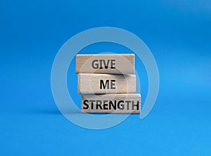 Give me strength symbol. Concept word Give me strength on wooden blocks. Beautiful blue background. Business and Give me strength