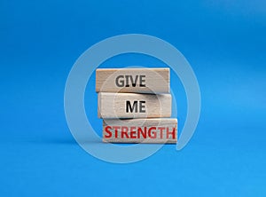 Give me strength symbol. Concept word Give me strength on wooden blocks. Beautiful blue background. Business and Give me strength