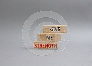 Give me strength symbol. Concept word Give me strength on wooden blocks. Beautiful grey background. Business and Give me strength