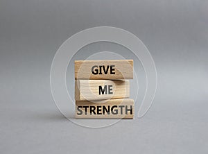 Give me strength symbol. Concept word Give me strength on wooden blocks. Beautiful grey background. Business and Give me strength