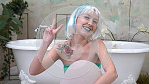 Give peace a chance. Portrait of a pretty young woman showing the peace sign in the bathroom