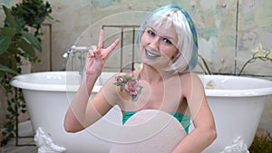 Give peace a chance. Portrait of a pretty young woman showing the peace sign in the bathroom