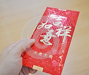 Give red packet `Ang Pao` in Chinese New Year holidays