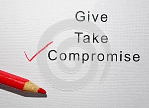 Give Take and Compromise text with red pencil check mark on paper