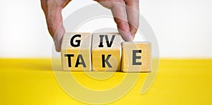Give or take symbol. Concept word Give or Take on wooden cubes. Beautiful yellow table white background. Businessman hand.
