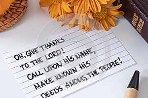 Give thanks to the LORD, handwritten Christian verse with pumpkin, autumn flowers, and holy bible