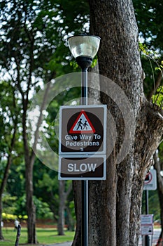 Give way to pedestrians sign. Slow down for safety