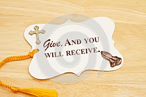 Give and you will receive message gift tag with yellow ribbon praying hands and cross