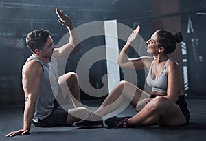 Give it your best and get what youve always wanted. a young man and woman giving each other a high five at the gym.