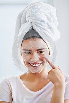 Give your skin the moisture it needs. Portrait of a beautiful young woman applying moisturizer to her skin in the