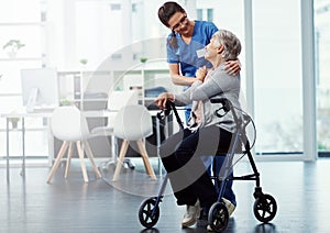 She gives her patients 100. Full length shot of a young female nurse talking to her senior patient in the old age home.