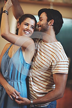 He gives me butterflies. an affectionate young couple dancing in their kitchen at home.