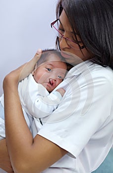 Giving comfort. A young infant with a cleft palate being comforted ber her mother.