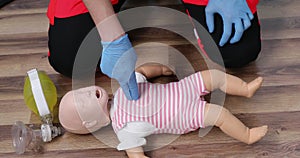 Giving first aid on a child dummy. Practitioners training medical learning on a baby mannequin. Emergency course for resuscitation