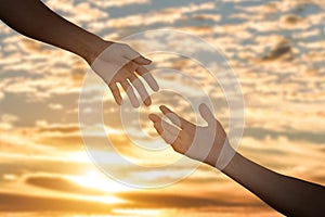 Giving a help hand concept. Reaching hand helping, hope and support each other over sunset