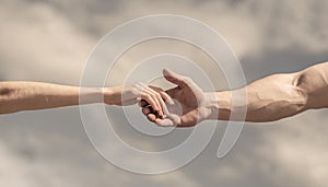 Giving a helping hand. Hands of man and woman on blue sky background. Lending a helping hand. Solidarity, compassion