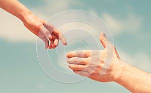 Giving a helping hand. Hands of man and woman on blue sky background. Lending a helping hand. Solidarity, compassion