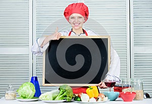 Giving her approval. Pretty woman gesturing thumbs up with empty blackboard. Master cook at cooking class. Chief cook