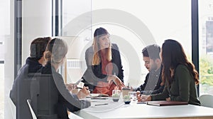 Giving her team a better sense of direction. a young businesswoman giving a presentation to her colleagues in an office.