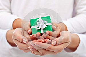 Giving a present - child and woman hands with gift box