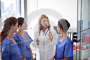 Giving them their instructions. Shot of a female doctor assigning tasks to a group of nurses at a hospital.