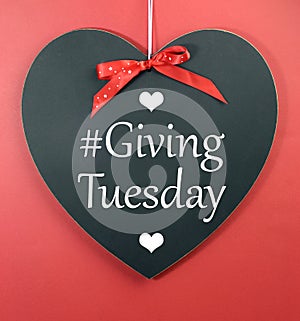 Giving Tuesday message greeting on black heart shape blackboard