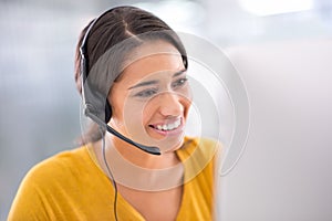 Giving you expert advice over the phone. a young customer service representative wearing a headset while sitting by her