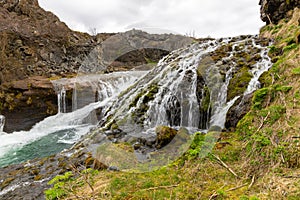 Gjain Canyon landscape with small waterfalls and lush vegetation, Iceland