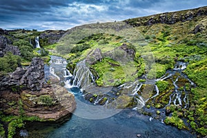 Gjain waterfall flowing in Pjorsardalur lush valley during summer at Iceland