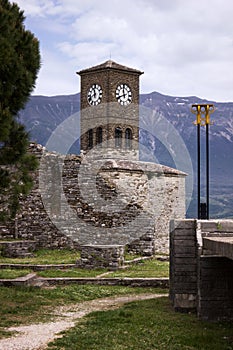 Gjirokastra Castle with a clock, Albania. Albanian fortress against the backdrop of mountains