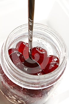 Glace cherries ingredients in a vintage jar on white