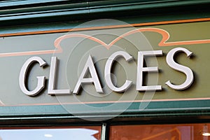 Glaces french text means ice cream sign facade store front of wall shop