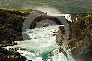 Glacial river with Godafoss waterfall in background, Iceland