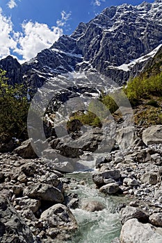 Glacial stream in alpine valley rugged terrain