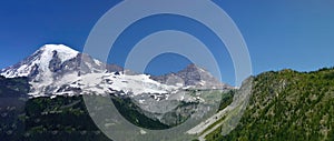 Glaciated summit of the mountain rises from forests photo