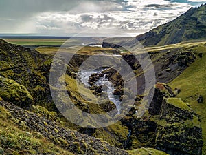 A Glaciel River runs through an Icelandic Landscape.