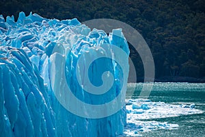 Glacier against the background of a forest on the shore of the water. Shevelev.