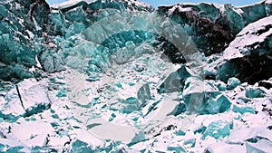 Glacier of beautiful unique turquoise color on background of snow in Arctic.