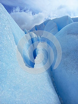 Glacier crack background under blue sky. Trekking, adventure and extreme nature