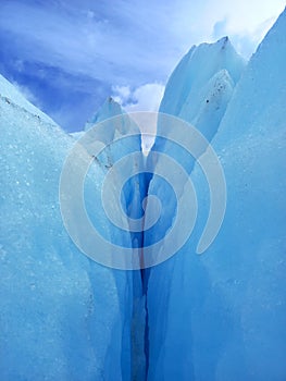 Glacier crack background under blue sky. Trekking, adventure and extreme nature