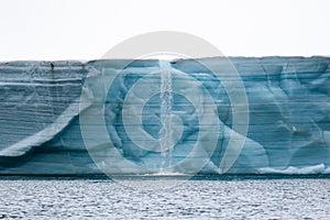 A glacier with floating sea ice north of Svalbard in the Arctic, with water falls