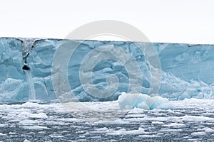 A glacier with floating sea ice north of Svalbard in the Arctic, with water falls