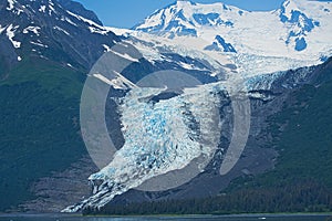 The glacier flows into the lake, which has bits of ice on the surface.