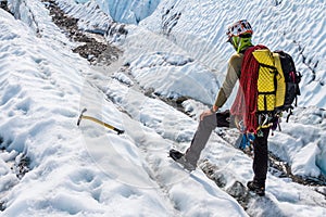 Glacier guide evaluating terrain while trekking across the Matanuska Glacier in Alaska