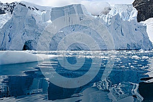 Glacier ice shelf in Antarctica, majestic blue and white glacier edge reflecting in blue sea water, Paradise Bay, Antarctica
