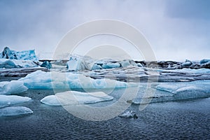 Glacier icebergs and water, dim cloudy light