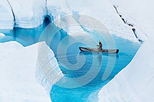 Glacier kayaking over ice cave and deep blue lake in the rain